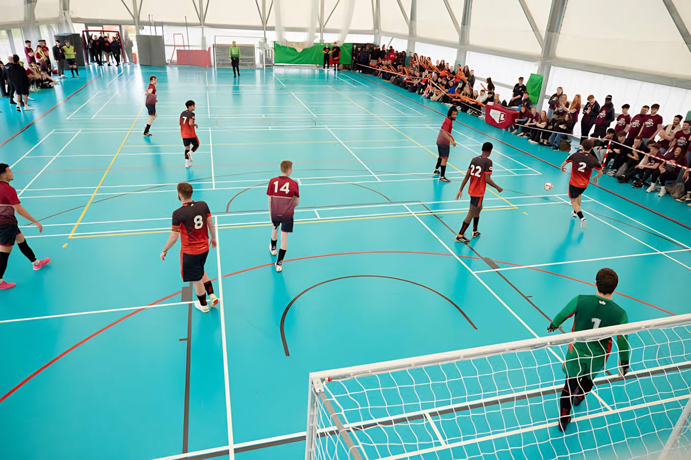 A futsal match in front of a crowd in the university sports hall